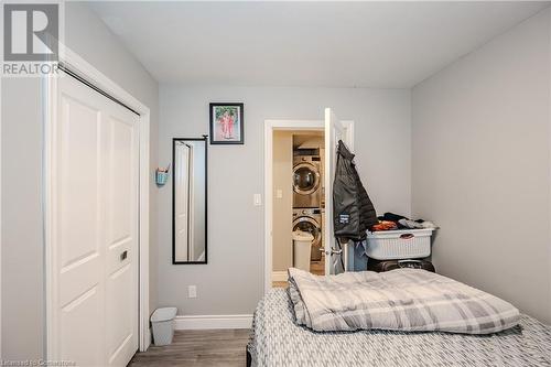 Bedroom featuring stacked washer and dryer, hardwood / wood-style flooring, and a closet - 82 Conway Drive, Kitchener, ON - Indoor Photo Showing Bedroom