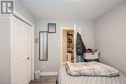 Bedroom featuring stacked washer and dryer, hardwood / wood-style flooring, and a closet - 