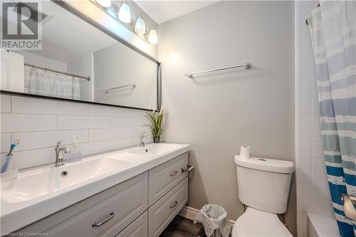 Bathroom featuring toilet, curtained shower, vanity, and decorative backsplash - 82 Conway Drive, Kitchener, ON - Indoor Photo Showing Bathroom