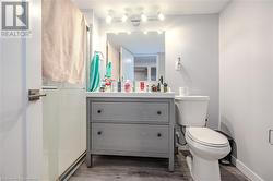 Bathroom with vanity, toilet, hardwood / wood-style floors, and a shower - 