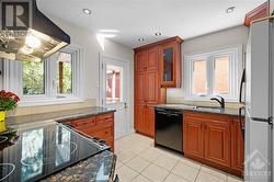 Updated kitchen with cherry coloured cabinets and granite counters - 