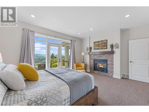 2707 Cliffshore Drive, Lake Country, BC - Indoor Photo Showing Bedroom With Fireplace