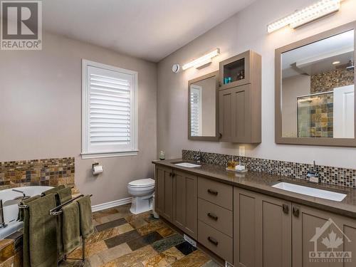 This spa like ensuite has custom tiles and back splash. Adds a touch of elegance to the room.  And you don't have to share your sink! - 322 Tucana Way, Ottawa, ON - Indoor Photo Showing Bathroom