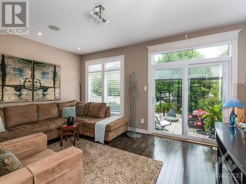 The abundance of glass doors and windows make the sunroom bright, even on a cloudy day. Great place to have your morning coffee in the morning sun. And you will never need to clean the blinds in t - 322 Tucana Way, Ottawa, ON - Indoor Photo Showing Living Room