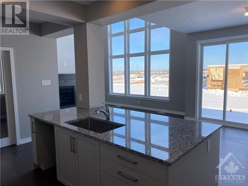 View from the kitchen through to the Great Room and sliding patio door to the rear yard - 126 Boulonnaius Grove, Kanata, ON - Indoor Photo Showing Kitchen