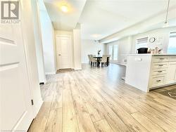 Kitchen with pendant lighting, white cabinetry, french doors, and light wood-type flooring - 