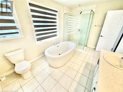 Full bathroom featuring vanity, shower with separate bathtub, and toilet - 