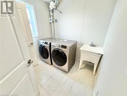 Clothes washing area with sink and washer and dryer - 