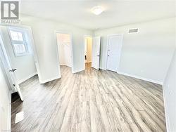 Unfurnished bedroom featuring a spacious closet, light hardwood / wood-style flooring, and a closet - 