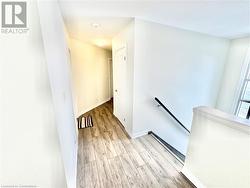 Corridor with a textured ceiling and light wood-type flooring - 