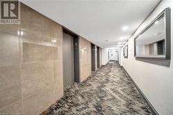 Hall with elevator, carpet floors, and a textured ceiling - 