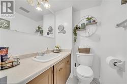 Bathroom with toilet, vanity, and an inviting chandelier - 