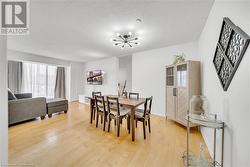 Dining room featuring a textured ceiling, hardwood / wood-style floors, and a chandelier - 