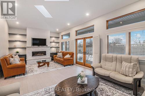 French doors lead to yard with covered porch - 586 Pleasant Park Road, Ottawa, ON - Indoor Photo Showing Living Room With Fireplace