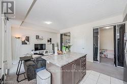 Kitchen featuring open floor plan, light countertops, dark brown cabinetry, and a center island - 