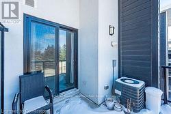 View of exterior entry with central AC, visible vents, and stucco siding - 