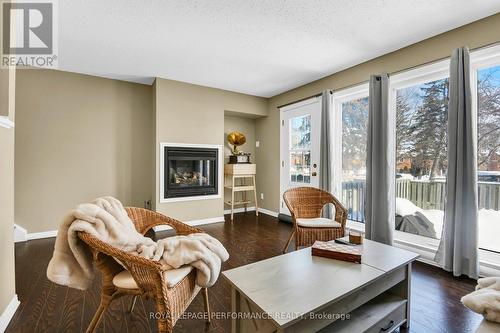 Cozy living space with big windows & door to yard - 222 Huntridge, Ottawa, ON - Indoor Photo Showing Living Room With Fireplace