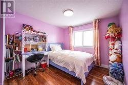 Bedroom with a textured ceiling, baseboards, and dark wood-type flooring - 