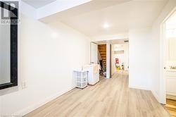 Empty room featuring light wood-style floors, stairs, and baseboards - 