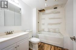 Full bathroom featuring vanity, toilet, and wood finished floors - 