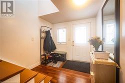 Doorway featuring a healthy amount of sunlight, a textured ceiling, and wood finished floors - 