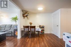 Dining area featuring a textured ceiling, baseboards, and dark wood-type flooring - 