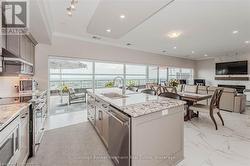 Kitchen featuring light stone counters, visible vents, a kitchen island with sink, a sink, and dishwasher - 