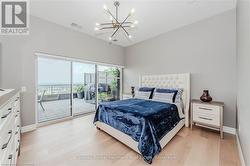 Bedroom featuring access to outside, a notable chandelier, visible vents, light wood-type flooring, and baseboards - 