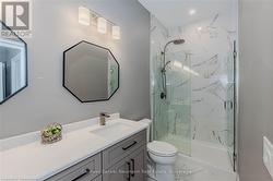 Bathroom with a marble finish shower, marble finish floor, vanity, and toilet - 