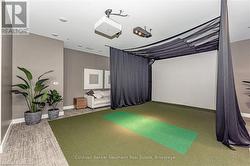 Recreation room featuring golf simulator, visible vents, and baseboards - 