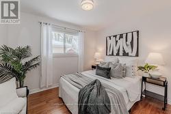 Bedroom featuring dark wood finished floors and baseboards - 