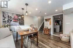 Dining space featuring stairs, dark wood-style flooring, and recessed lighting - 