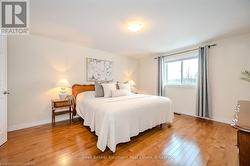 Bedroom featuring light wood-type flooring and baseboards - 