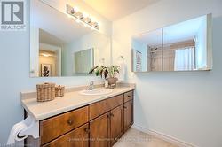 Bathroom featuring a shower with curtain, tile patterned flooring, vanity, and baseboards - 