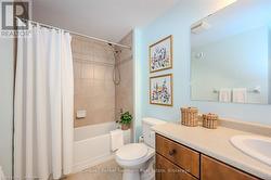 Bathroom featuring tile patterned flooring, toilet, visible vents, vanity, and shower / bath combo with shower curtain - 