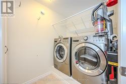 Laundry room with laundry area, independent washer and dryer, baseboards, and tile patterned floors - 