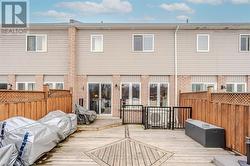 Rear view of property featuring brick siding, fence, and a deck - 