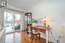 Home office featuring lofted ceiling, visible vents, and light wood-style flooring - 