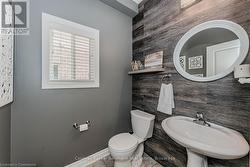 Bathroom featuring a sink, toilet, and baseboards - 