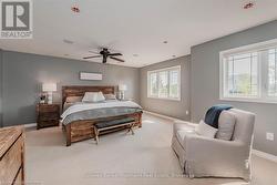 Bedroom featuring ceiling fan, baseboards, and light colored carpet - 