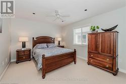 Bedroom with light carpet, a ceiling fan, and baseboards - 