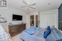 Carpeted bedroom with a textured ceiling, a ceiling fan, and a closet - 