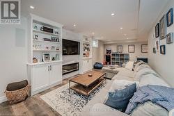 Living area with light wood-style floors, recessed lighting, and a large fireplace - 