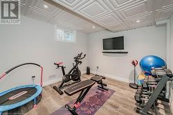 Workout area with an ornate ceiling, recessed lighting, baseboards, and wood finished floors - 