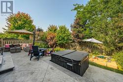 View of patio with a hot tub, outdoor lounge area, and a fenced backyard - 