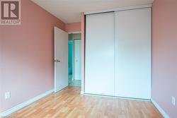 Unfurnished bedroom featuring a closet, baseboards, and wood finished floors - 