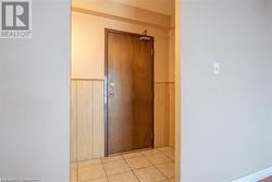 Hallway with a wainscoted wall and light tile patterned flooring - 