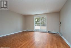 Empty room with baseboards, a baseboard radiator, and light wood-style floors - 