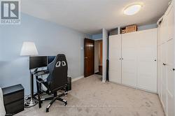 Office area with a textured ceiling, baseboards, and light colored carpet - 