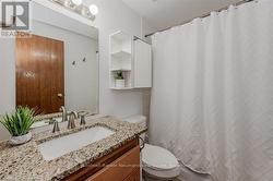 Full bathroom with toilet, a shower with shower curtain, and vanity - 